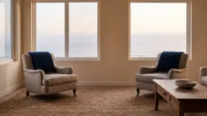 Two empty chairs facing each other across a room in cool evening light