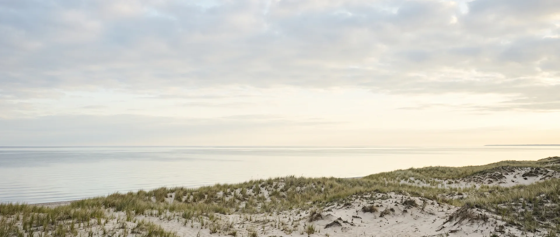A wide lakefront at dawn under an open midwestern sky